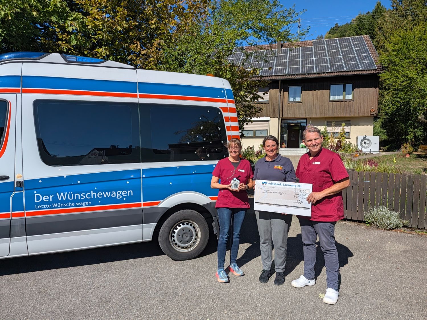 Scheckübergabe über 1.366 Euro an den Wünschewagen Ludwigsburg vor dem Wünschewagen-Fahrzeug